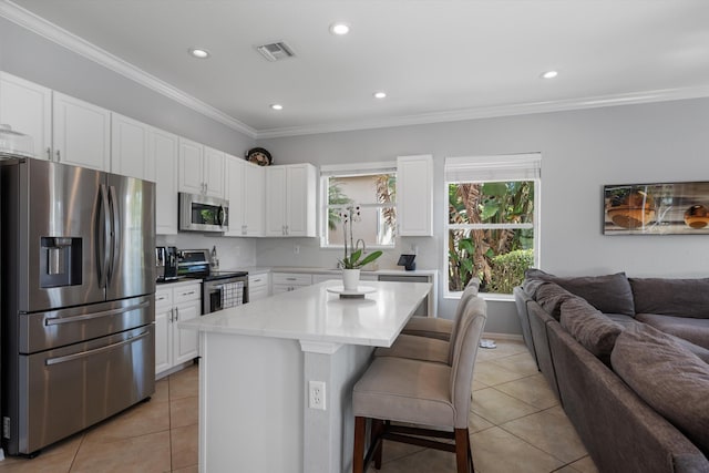 kitchen with a kitchen island, white cabinetry, a kitchen bar, light tile patterned floors, and stainless steel appliances