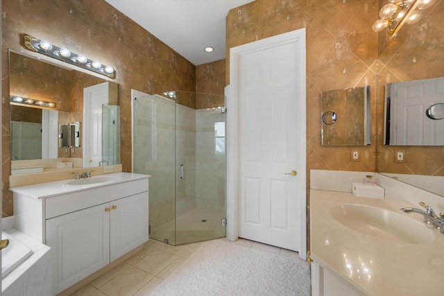 bathroom featuring tile patterned flooring, vanity, tile walls, and walk in shower