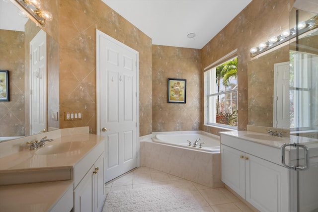 bathroom featuring tile patterned floors, tiled bath, tile walls, and vanity