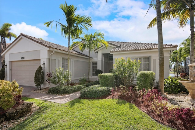 mediterranean / spanish home with a garage and a front yard