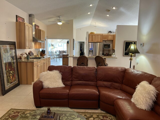 dining space featuring ceiling fan, lofted ceiling, light tile patterned floors, and a textured ceiling