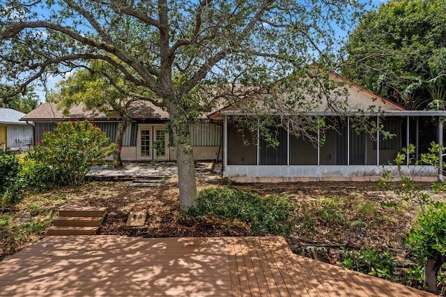 back of house featuring a wooden deck and a sunroom