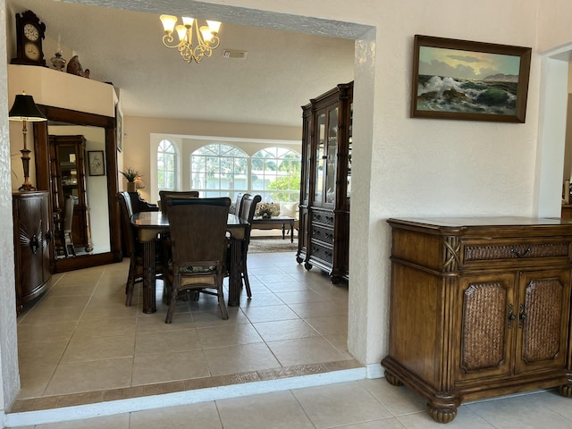 tiled dining area featuring a chandelier and a textured ceiling