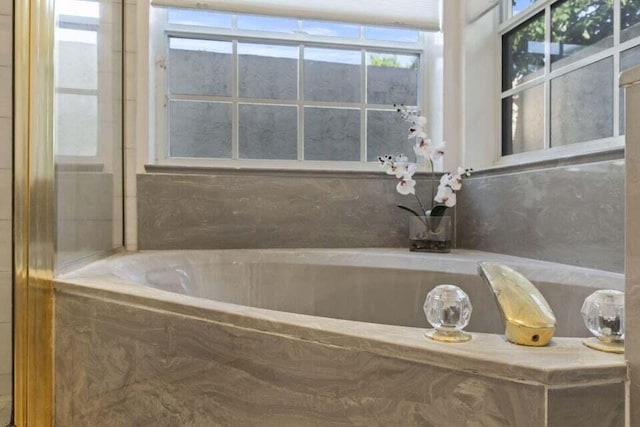 bathroom with a relaxing tiled tub