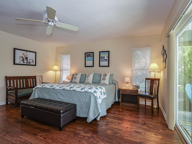 bedroom featuring multiple windows, a textured ceiling, dark hardwood / wood-style floors, and ceiling fan