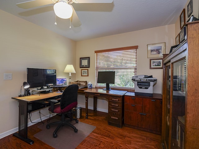 home office with dark hardwood / wood-style flooring and ceiling fan