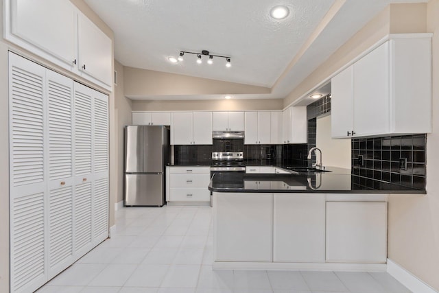 kitchen featuring sink, vaulted ceiling, kitchen peninsula, stainless steel appliances, and white cabinets