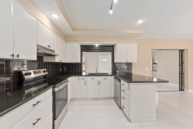 kitchen featuring white cabinetry, sink, kitchen peninsula, and appliances with stainless steel finishes