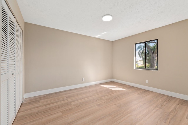 unfurnished bedroom featuring a textured ceiling and light wood-type flooring