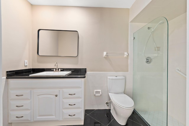 bathroom featuring walk in shower, toilet, tile walls, vanity, and tile patterned flooring