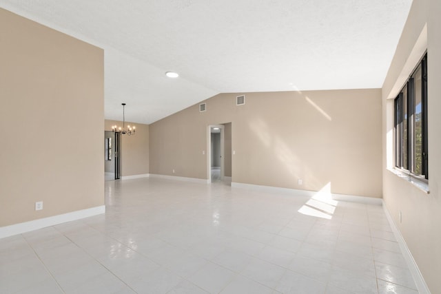 tiled empty room featuring vaulted ceiling and a chandelier