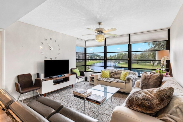 living room featuring ceiling fan and a textured ceiling