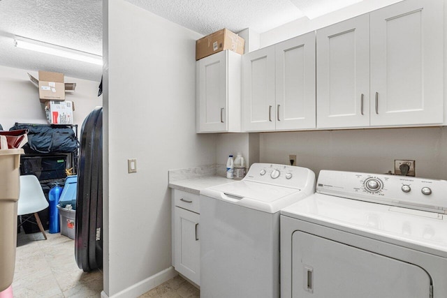 clothes washing area with cabinets, independent washer and dryer, and a textured ceiling