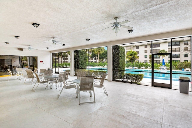 view of patio featuring a community pool and ceiling fan