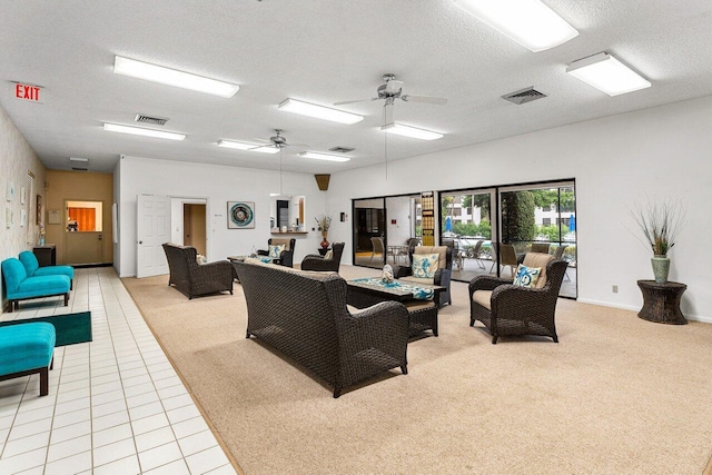 tiled living room with ceiling fan and a textured ceiling