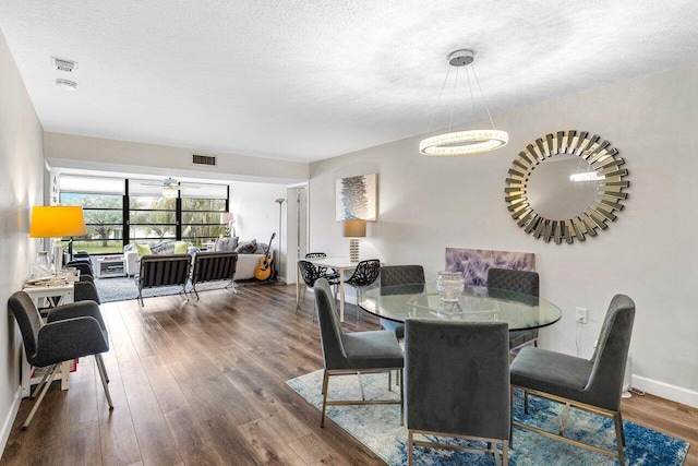 dining area with dark hardwood / wood-style floors and a textured ceiling