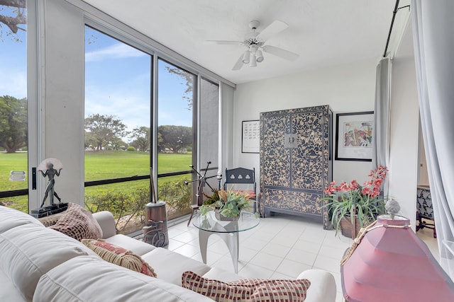 living room with a wall of windows, ceiling fan, and light tile patterned flooring