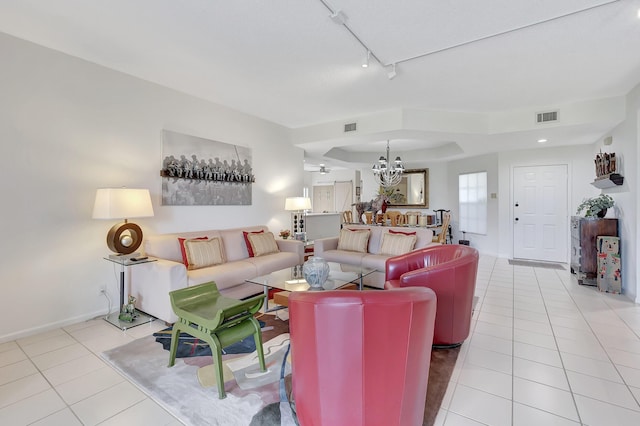 tiled living room featuring rail lighting and a notable chandelier