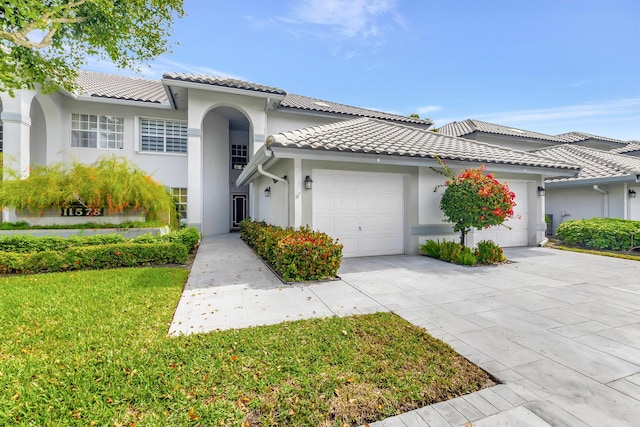 mediterranean / spanish-style house featuring a garage and a front yard