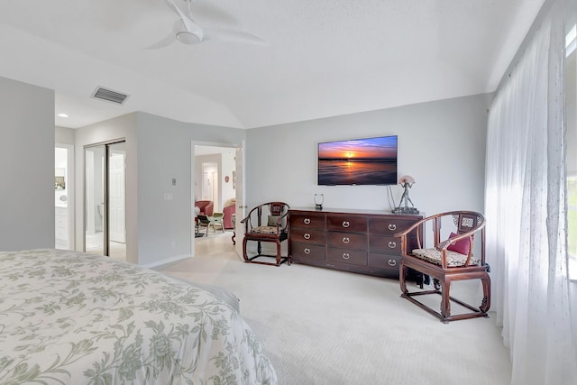 bedroom with ceiling fan, connected bathroom, light carpet, and a closet