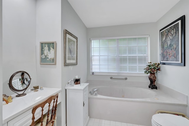 bathroom with tile patterned flooring, vanity, toilet, and a tub to relax in