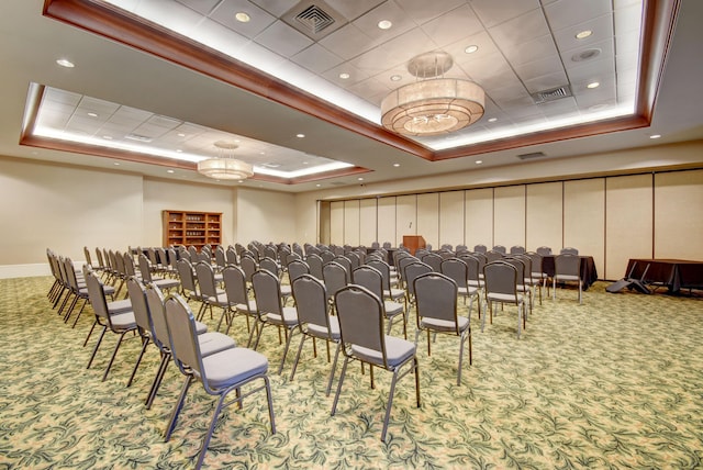 carpeted home theater room with ornamental molding and a tray ceiling