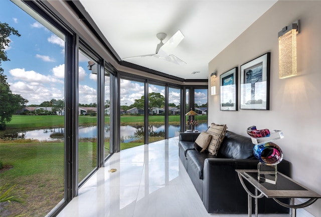 sunroom featuring a water view and ceiling fan