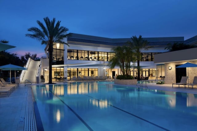 pool at dusk featuring a patio