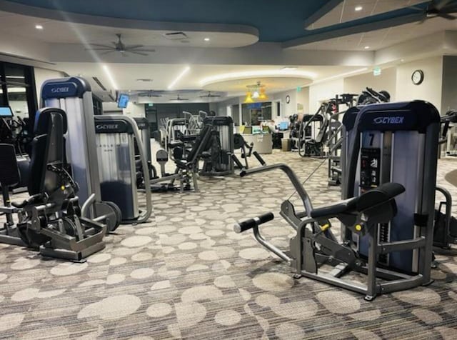 exercise room with ceiling fan and light carpet