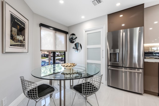 kitchen with light tile patterned floors, backsplash, and stainless steel fridge with ice dispenser