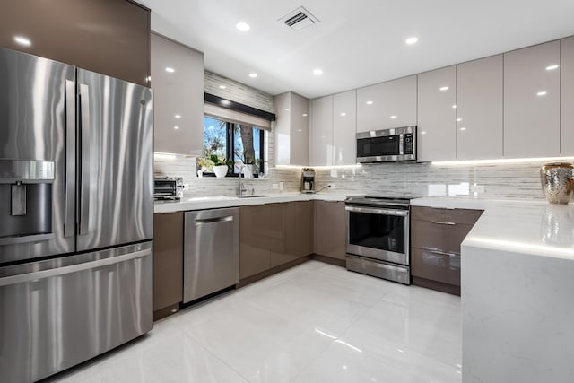 kitchen with white cabinetry, sink, tasteful backsplash, and stainless steel appliances