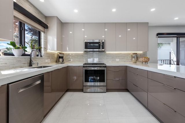 kitchen with light stone countertops, appliances with stainless steel finishes, white cabinets, and backsplash