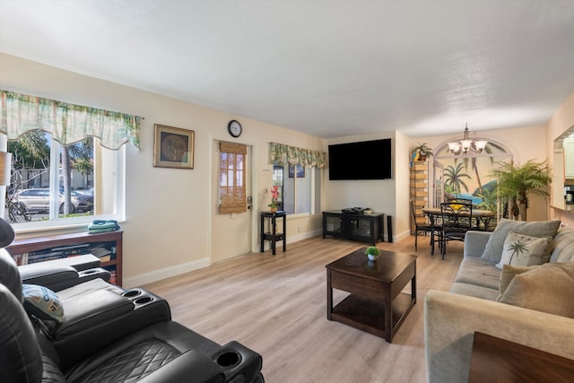 living room with a notable chandelier and light wood-type flooring