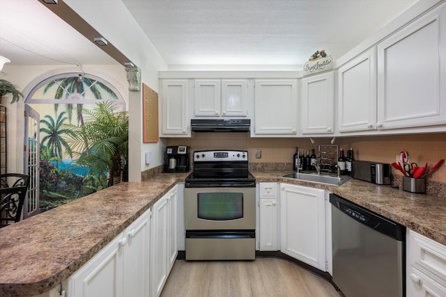 kitchen featuring white cabinetry, tasteful backsplash, stainless steel appliances, and range hood