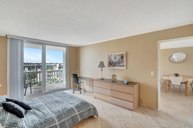 tiled bedroom featuring a textured ceiling, access to exterior, and a wall of windows