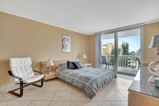 bedroom with access to exterior, expansive windows, a textured ceiling, and light tile patterned flooring