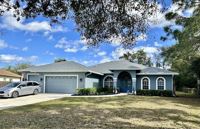 single story home featuring a garage and a front yard