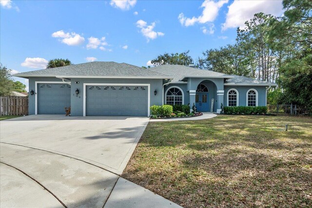 single story home featuring a garage and a front lawn