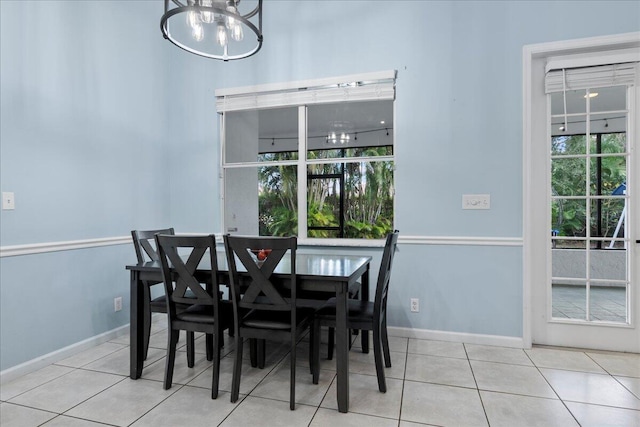 tiled dining room featuring an inviting chandelier