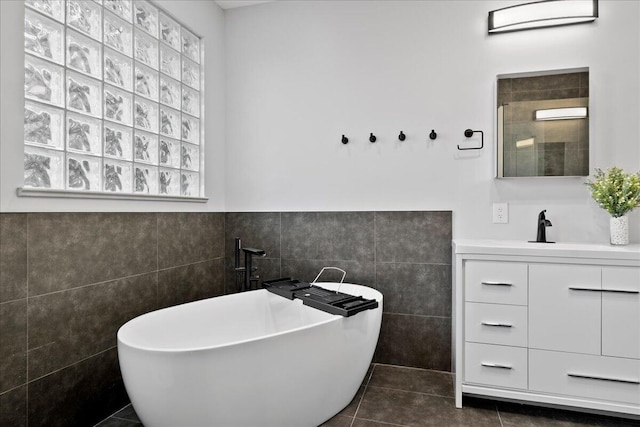 bathroom featuring vanity, tile walls, tile patterned floors, and plus walk in shower