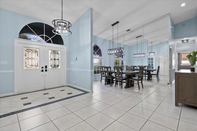 tiled entrance foyer featuring lofted ceiling, plenty of natural light, and an inviting chandelier