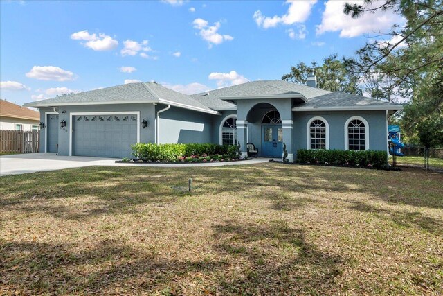 single story home featuring a garage and a front lawn