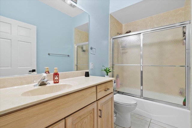 full bathroom featuring vanity, toilet, tile patterned flooring, and combined bath / shower with glass door