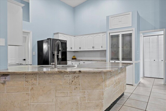 kitchen featuring range with two ovens, white cabinetry, and light tile patterned flooring