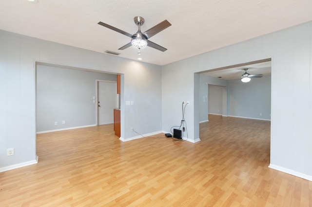 empty room with a textured ceiling, ceiling fan, and light wood-type flooring