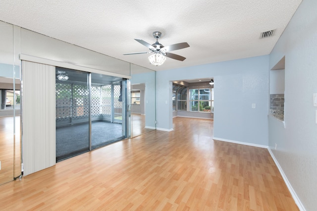 empty room with hardwood / wood-style floors, a textured ceiling, and ceiling fan