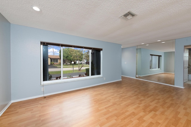 empty room featuring light hardwood / wood-style floors and a textured ceiling