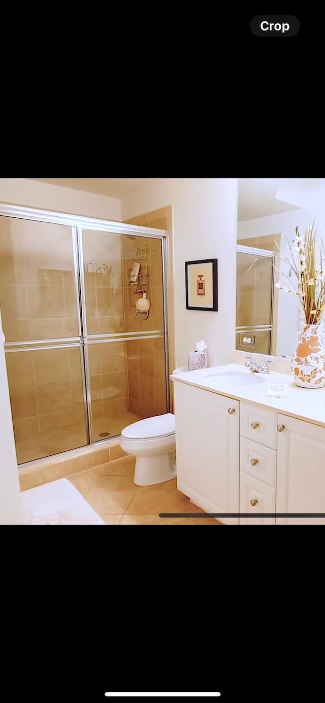 bathroom featuring tile patterned floors, toilet, an enclosed shower, and vanity