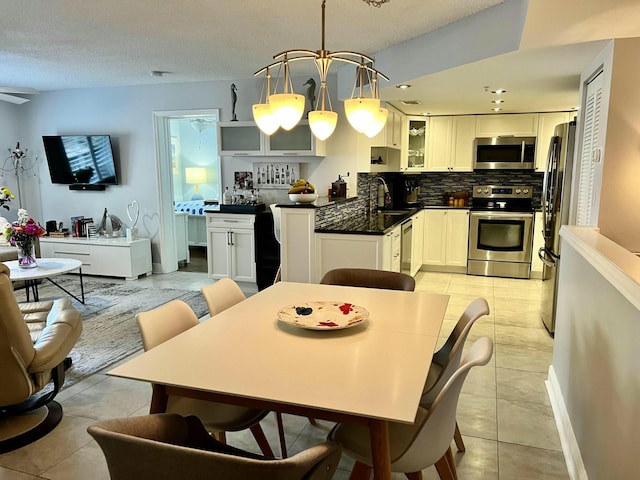 kitchen featuring white cabinetry, stainless steel appliances, light tile patterned flooring, and sink