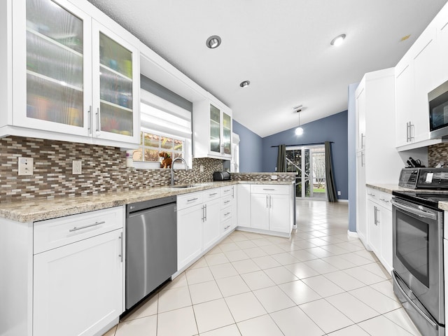 kitchen featuring a peninsula, tasteful backsplash, a wealth of natural light, and stainless steel appliances